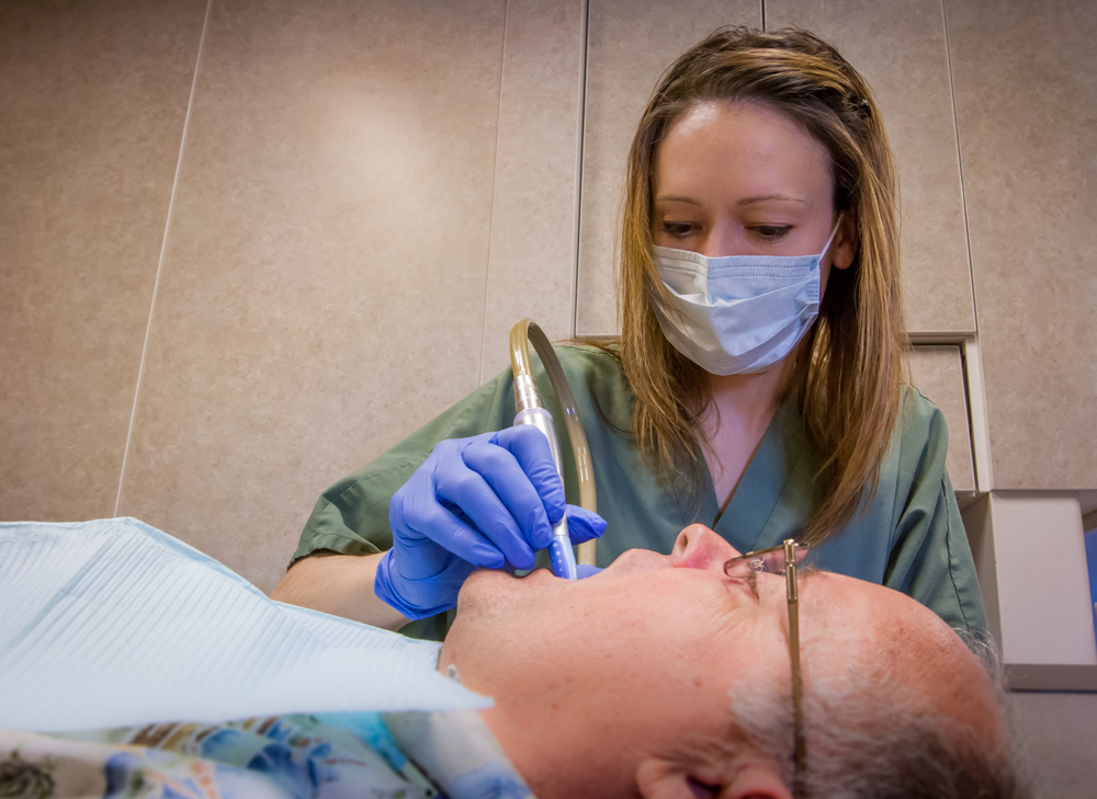 FSC dental hygienist works on a patient.
