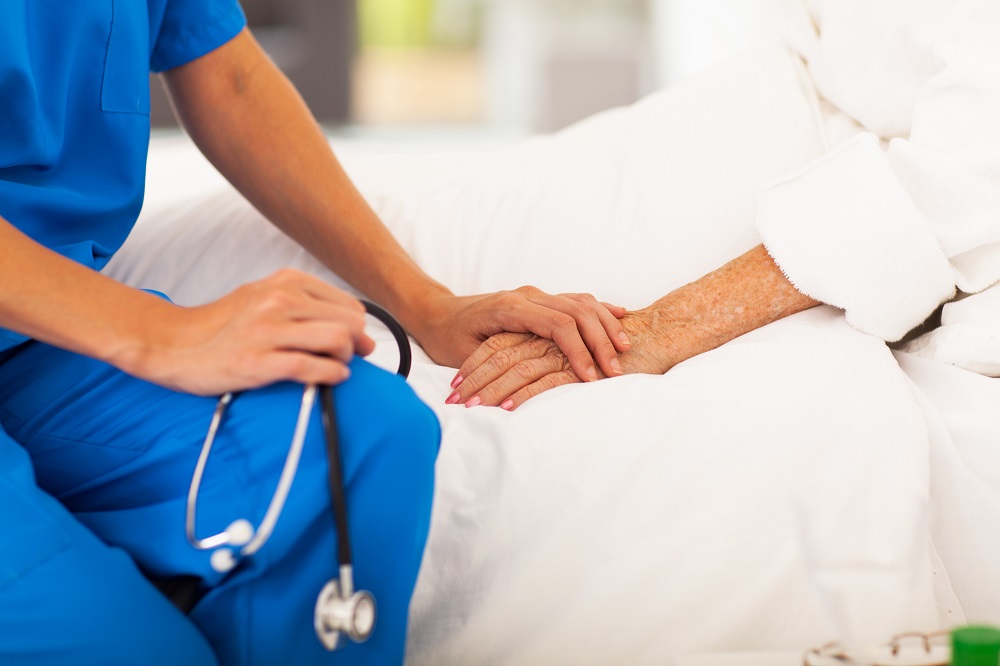 nurse holding patient's hand